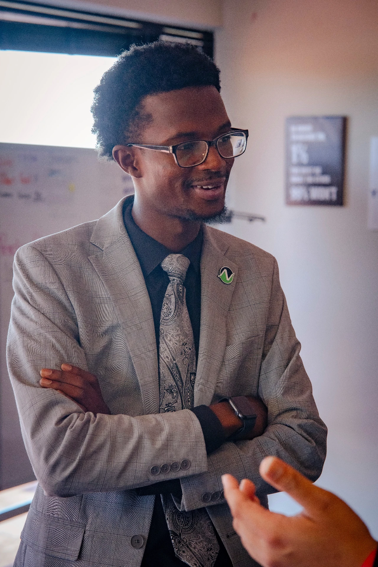A professional man in a suit engages in conversation, showcasing a collaborative atmosphere in a business setting.