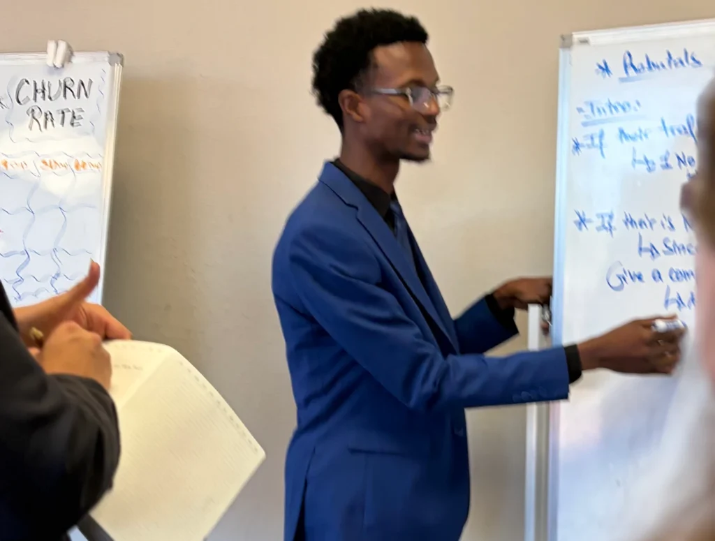 A professional presenting strategies on a whiteboard during a career development workshop.
